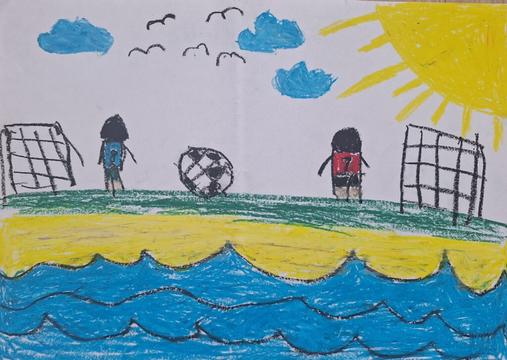 Eine farbenfrohe Buntstiftzeichnung zeigt zwei Kinder, die auf einer Wiese in der Nähe des Strandes Fußball spielen, mit einem Ball zwischen zwei Toren, blauen Wellen im Vordergrund, einer hellen Sonne, Wolken und Vögeln am Himmel.
